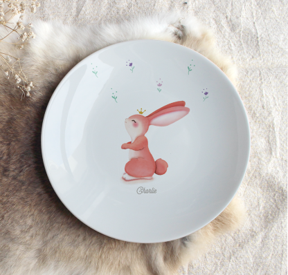 Assiette en porcelaine lapin rose avec fleurs autour et prénom personnalisable.
